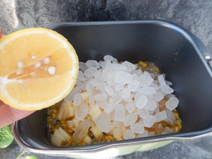 面包机桶中，加入百香果果肉，放上苹果和冰糖，挤适量柠檬汁
