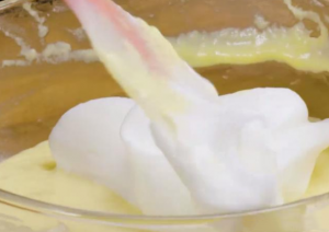 然后把蛋白霜和蛋黄糊均匀搅拌融合，之后倒入准备好的酸奶，均匀翻拌1分钟